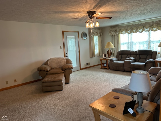 living room featuring ceiling fan, carpet flooring, and a textured ceiling