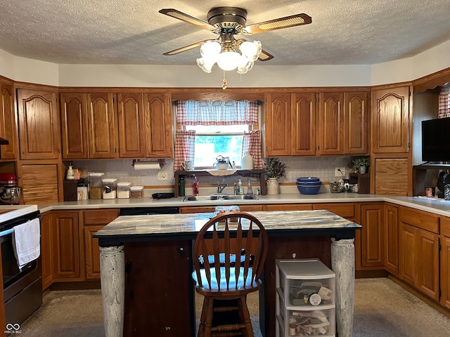 kitchen featuring stainless steel range with electric stovetop, a textured ceiling, a kitchen island, and sink