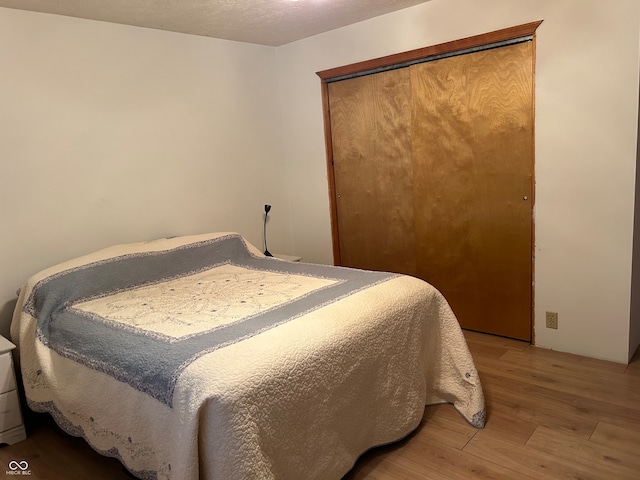 bedroom with light hardwood / wood-style flooring and a closet