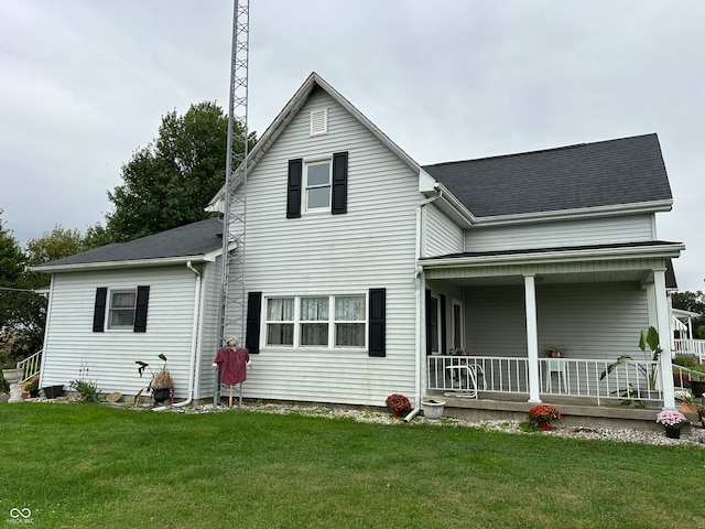 back of property with a yard and covered porch