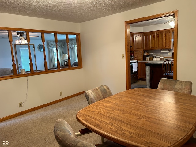 carpeted dining room with a textured ceiling and ceiling fan