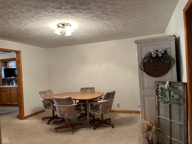 dining area with light carpet and a textured ceiling