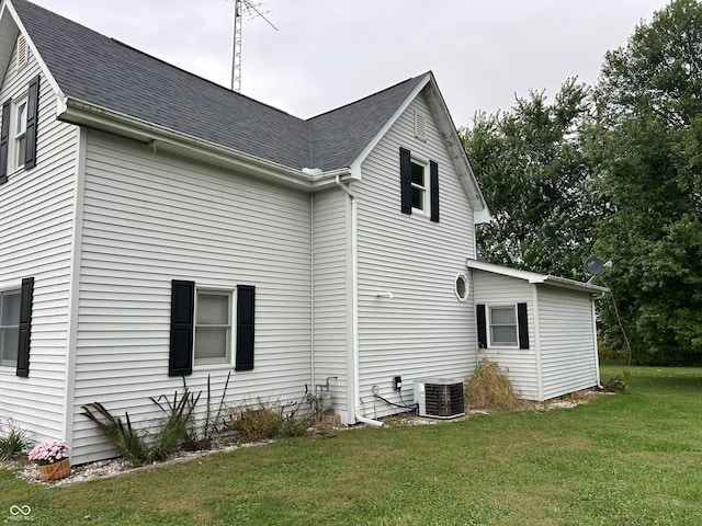 view of side of property with a yard and central air condition unit