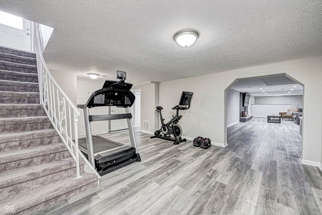 workout room with hardwood / wood-style flooring and a textured ceiling