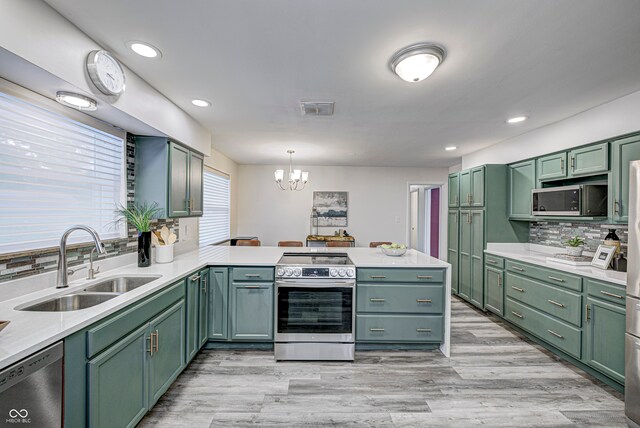 kitchen with decorative light fixtures, green cabinetry, stainless steel appliances, and sink