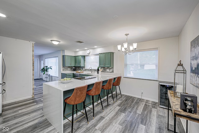 kitchen featuring a breakfast bar area, hardwood / wood-style floors, kitchen peninsula, and a wealth of natural light