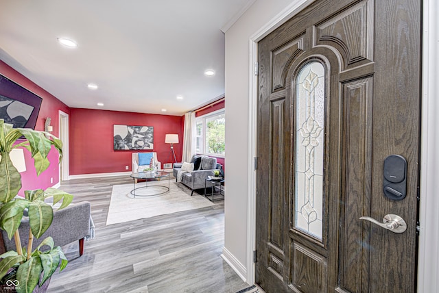 foyer entrance featuring light hardwood / wood-style flooring and ornamental molding