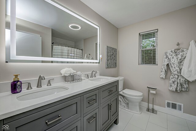 bathroom featuring a shower with curtain, vanity, toilet, and tile patterned floors