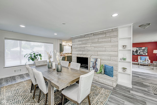 dining area featuring hardwood / wood-style floors and a stone fireplace