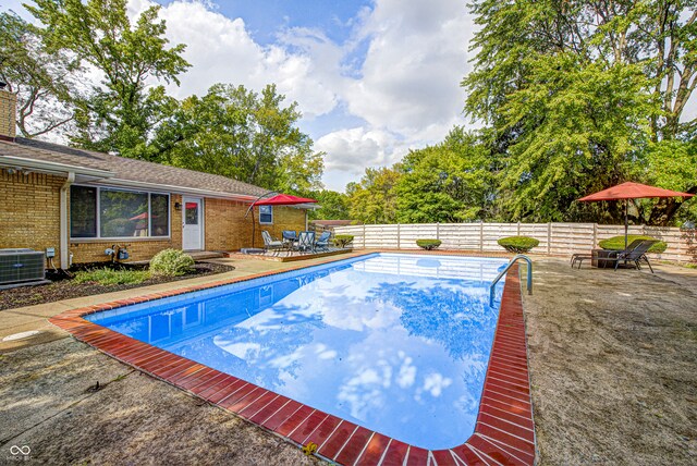 view of swimming pool with central AC unit