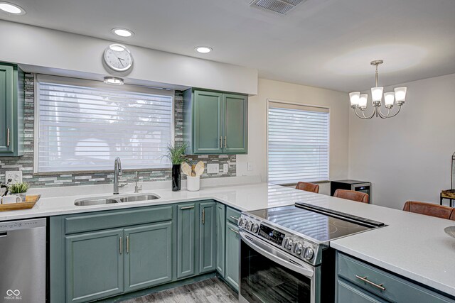 kitchen featuring decorative backsplash, stainless steel appliances, pendant lighting, and sink