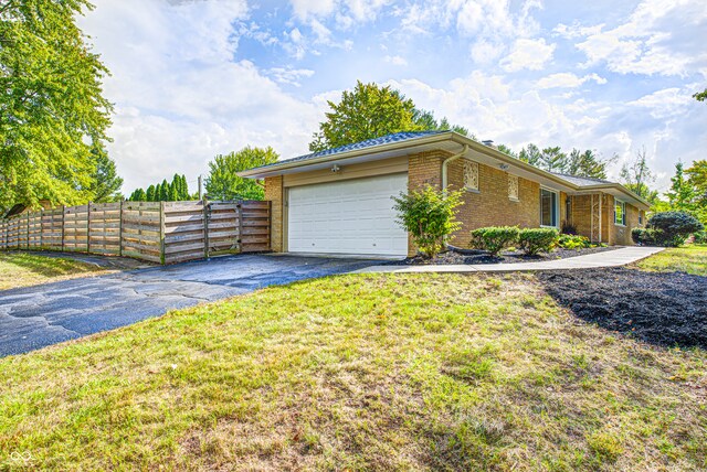 view of side of home featuring a garage and a yard