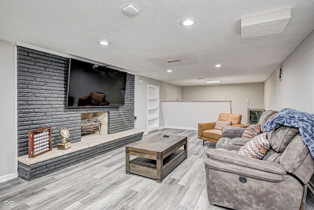 living room featuring light wood-type flooring and a textured ceiling