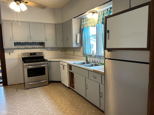 kitchen featuring ceiling fan, sink, tasteful backsplash, white appliances, and gray cabinets