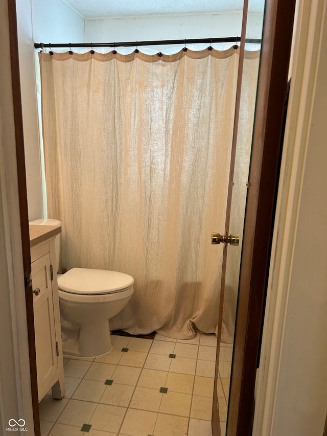 bathroom featuring tile patterned flooring, vanity, and toilet