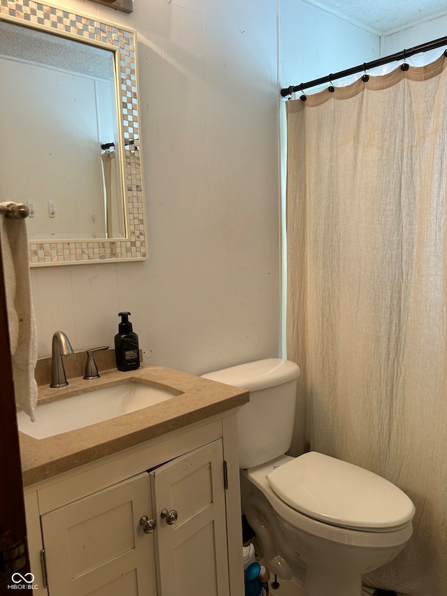 bathroom featuring vanity, toilet, a textured ceiling, and curtained shower