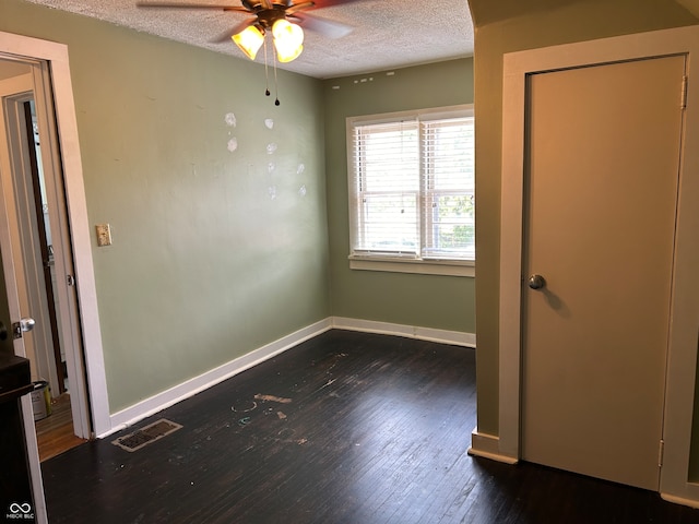 unfurnished room featuring ceiling fan, dark hardwood / wood-style flooring, and a textured ceiling