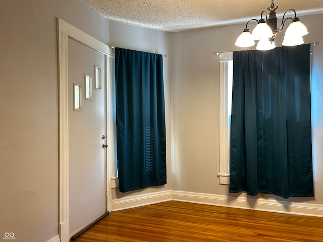 interior space featuring a chandelier, hardwood / wood-style flooring, and a textured ceiling