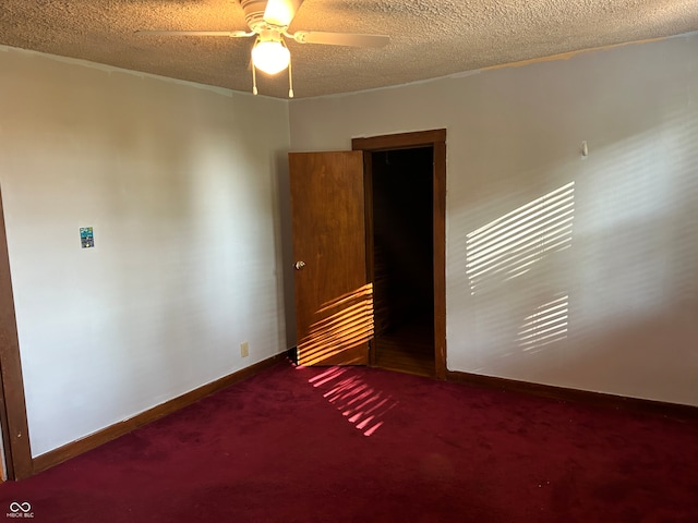 empty room featuring ceiling fan, carpet, and a textured ceiling