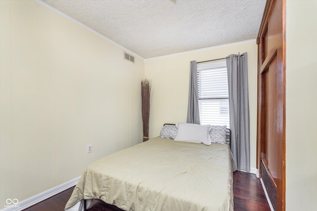 bedroom featuring a textured ceiling, dark hardwood / wood-style floors, and crown molding