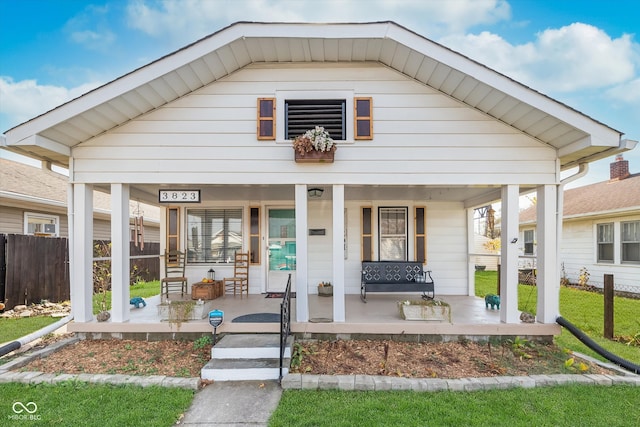 view of front of house featuring covered porch and a front lawn