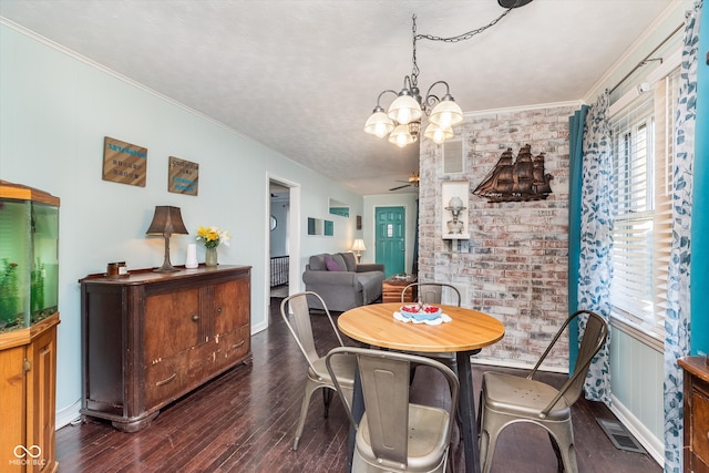 dining space featuring brick wall, crown molding, dark hardwood / wood-style floors, and ceiling fan with notable chandelier