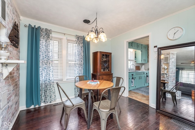 dining space featuring ceiling fan with notable chandelier, sink, dark hardwood / wood-style flooring, and ornamental molding