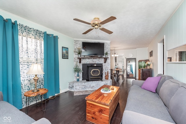 living room with a wood stove, wood-type flooring, ceiling fan, and crown molding