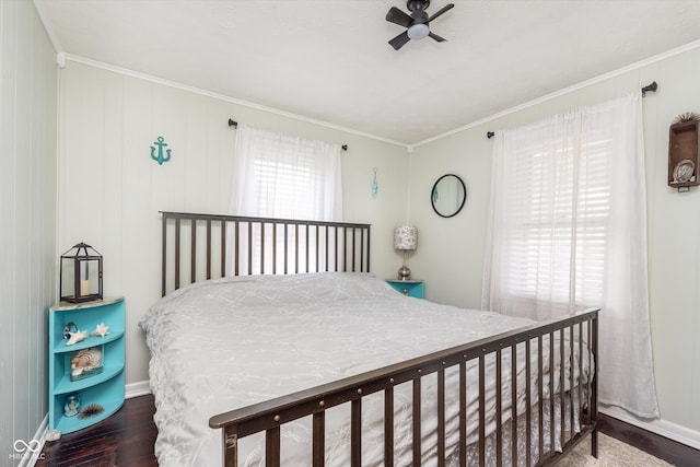 bedroom featuring ceiling fan, wooden walls, dark hardwood / wood-style flooring, and ornamental molding