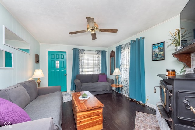 living room with wood-type flooring, a wood stove, wood walls, ornamental molding, and ceiling fan