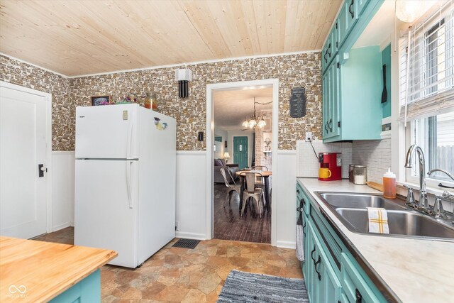 kitchen featuring sink, ornamental molding, an inviting chandelier, wood ceiling, and white fridge