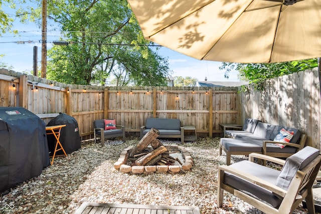 view of patio with an outdoor living space with a fire pit