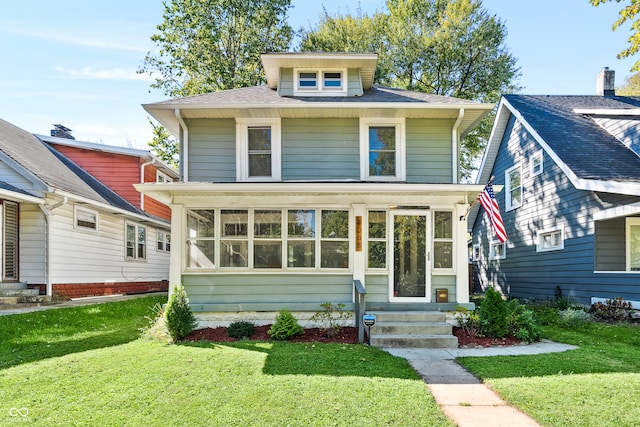 view of front of property with a front yard and a sunroom