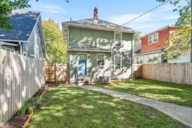 rear view of house featuring a yard and central AC unit