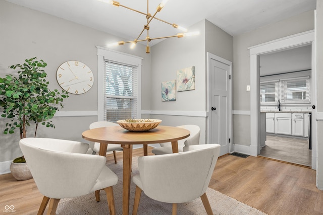 dining space with light hardwood / wood-style flooring and sink