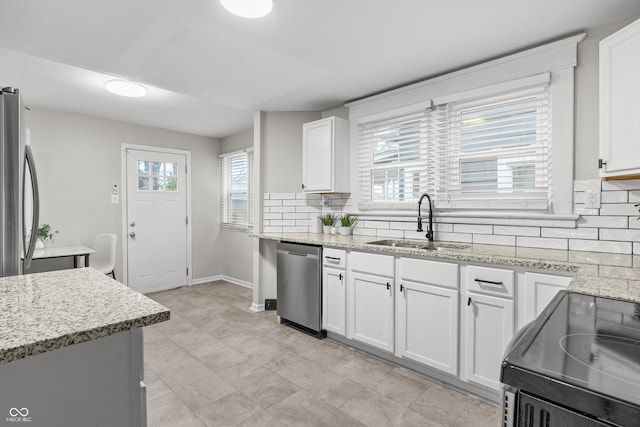 kitchen with white cabinets, appliances with stainless steel finishes, and a wealth of natural light