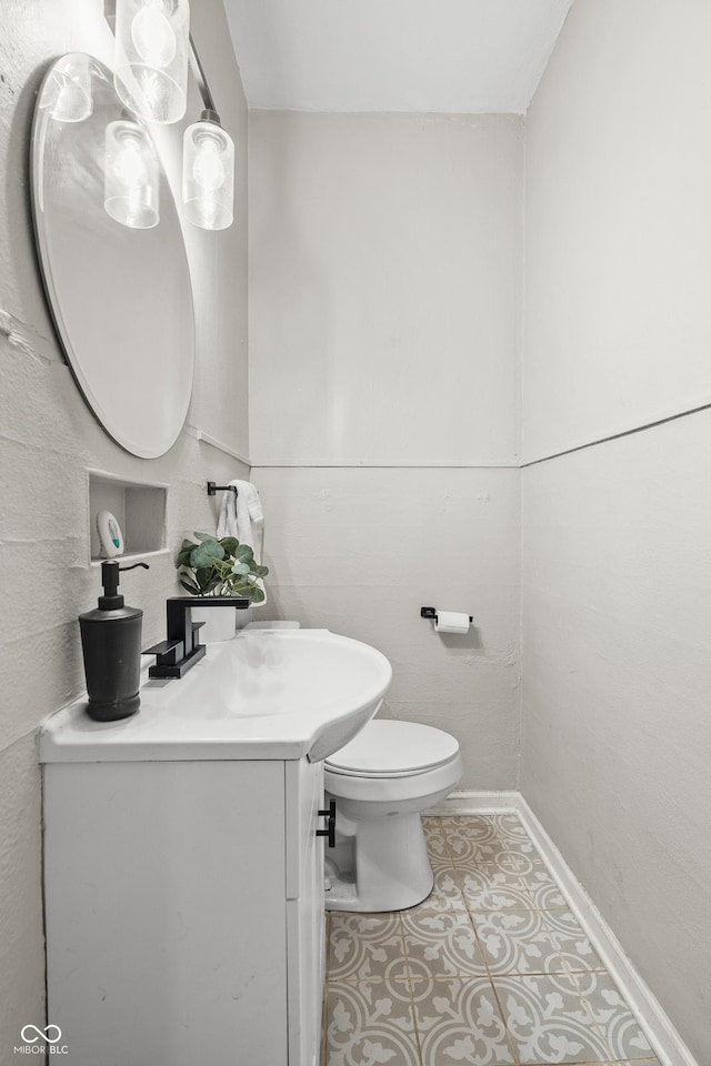 bathroom featuring tile patterned flooring, vanity, and toilet