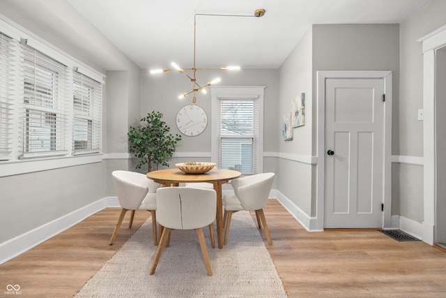 dining space featuring a notable chandelier and light hardwood / wood-style flooring