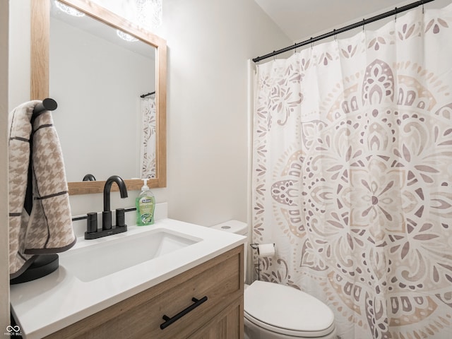 bathroom with walk in shower, vanity, and toilet