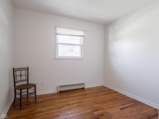 empty room featuring dark hardwood / wood-style floors and baseboard heating