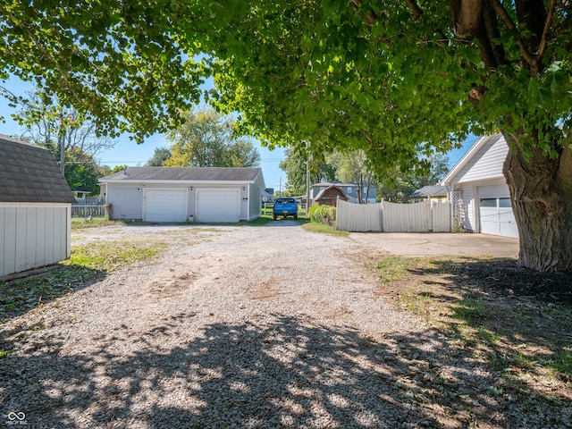 view of yard with a garage and an outbuilding