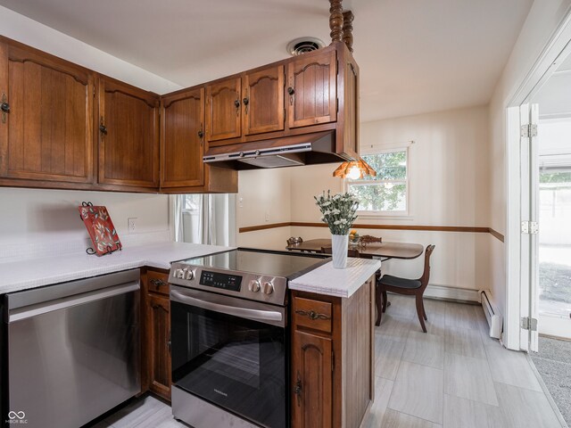 kitchen featuring appliances with stainless steel finishes, kitchen peninsula, and baseboard heating