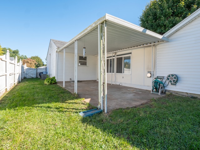 rear view of property featuring central AC unit, a yard, and a patio