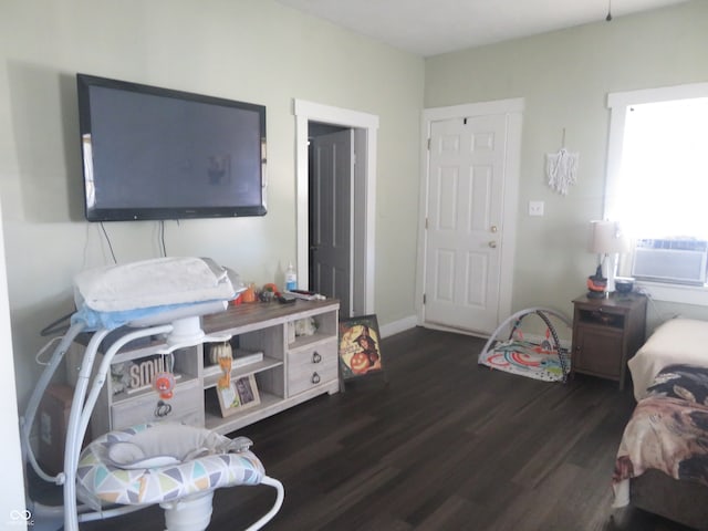 bedroom with cooling unit and dark hardwood / wood-style flooring