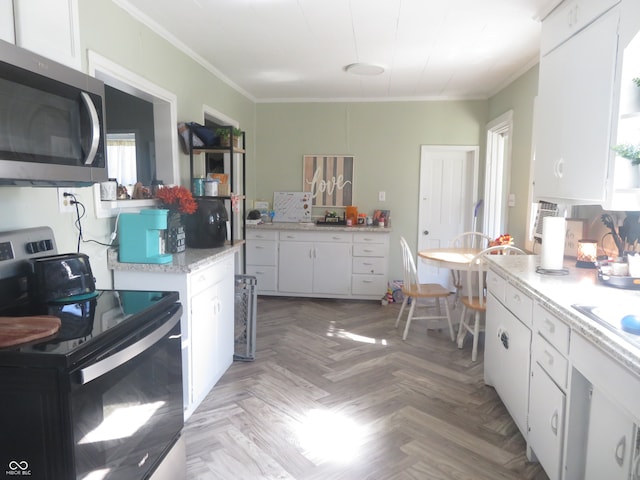 kitchen with light parquet flooring, stainless steel appliances, and white cabinets