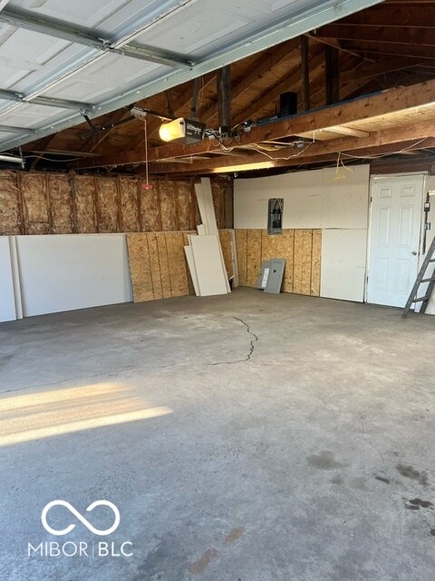 garage with a garage door opener and electric panel