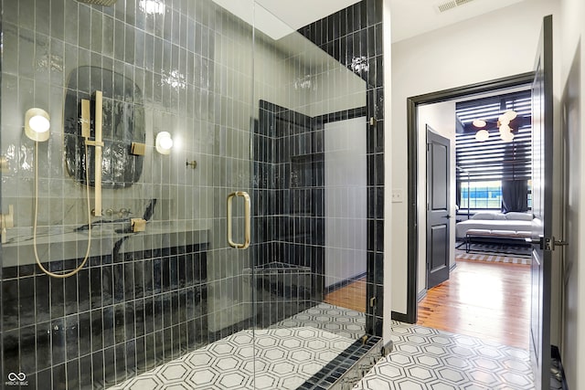 bathroom with hardwood / wood-style floors and an enclosed shower