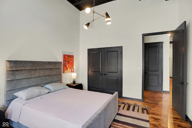 bedroom featuring a high ceiling, a closet, and light wood-type flooring