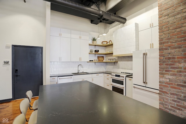 kitchen with hardwood / wood-style flooring, tasteful backsplash, sink, white cabinetry, and white appliances