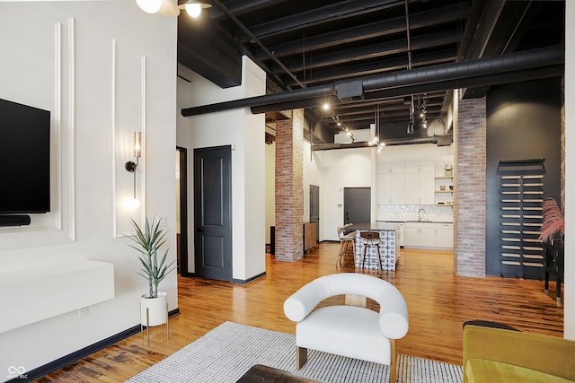 living room with light hardwood / wood-style floors, a high ceiling, and sink